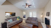 Located in Lewisville, TX, this well-appointed 2-bedroom, 2-bathroom single-story home offers a comfortable and functional layout. The living room serves as the heart of the home, showcasing vaulted ceilings, rich wood-look flooring, and a ceiling fan that adds to the airy feel. A fireplace anchors one wall, while French doors open directly to a private patio, filling the space with natural light. An open pass-through connects the living area to the kitchen, which features wood-toned cabinetry and dark appliances. The adjacent dining area accommodates everyday meals, with a window that lets in additional natural light. Both bedrooms are carpeted and equipped with ceiling fans. The spacious primary bedroom includes an en-suite bathroom and direct access to a dedicated closet. The second bedroom features a large window with outdoor views and its own closet. Each bathroom is fitted with wood-toned vanities and granite-style countertops, with one featuring a shower-tub combination. A dedicated laundry area adds everyday convenience. Throughout the home, neutral tones and consistent finishes create a cohesive, practical living environment.