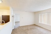 Located at 1059 Casitas Pass Rd in the charming coastal community of Carpinteria, California, this single-story, one-bedroom, one-bathroom unit offers a clean and functional layout ideal for comfortable everyday living. The single-floor plan maximizes efficiency while maintaining a welcoming atmosphere throughout.

The living area features wall-to-wall carpeting and a textured ceiling, with a large sliding glass door dressed in vertical blinds that fills the room with natural light and provides direct access to an outdoor patio area. An additional window further brightens the space, creating an airy, open feel.

The galley-style kitchen is well-appointed with white cabinetry, granite-look countertops, a stainless steel gas range, a refrigerator, and a sink integrated into a peninsula-style counter — offering both practicality and a clean aesthetic. Tile flooring runs throughout the kitchen, providing easy maintenance.

The bedroom is generously sized with soft carpeting, a textured ceiling, and a large window dressed in vertical blinds that allows ample natural light to filter in.

The bathroom is finished with tile flooring and features a combined shower and bathtub with a safety grab bar, a curtain rod, and a toilet — all presented in a clean, white palette that gives the space a fresh, well-maintained appearance.