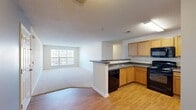 Located at 1009 Misty Mountain Rd in Lynchburg, Virginia, this single-story, 3-bedroom, 2-bathroom home offers a well-organized layout across a compact yet functional footprint. The open-concept kitchen and living area serves as the heart of the home, where wood-look flooring in the kitchen transitions seamlessly into carpeted living space. The kitchen is equipped with warm oak cabinetry, dark granite-style countertops, black appliances including a range, microwave, and refrigerator, and a peninsula with bar seating that doubles as a casual dining area. A double sink and built-in dishwasher add to its practicality.

The spacious living room benefits from a large window that draws in natural light and opens toward exterior views, creating an airy atmosphere. A dedicated entryway with a panel door provides a clear separation from the main living area.

The primary bedroom includes a ceiling fan, a walk-in closet, and direct access to an en-suite bathroom featuring a wood-tone vanity, white countertop, and a full soaking tub with shower. The second bathroom mirrors this aesthetic with hardwood-style floors and a similarly styled vanity. The additional bedrooms are carpeted and each include windows for natural light.