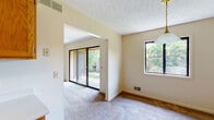 Located at 1413 Stowell Drive in Rochester, NY, this single-floor residence offers a well-organized layout with a variety of comfortable living spaces. The expansive living and dining area is highlighted by soft wall-to-wall carpeting, a textured ceiling, and an abundance of natural light streaming in through multiple windows and large sliding glass doors that open directly onto a private outdoor deck, providing pleasant views of surrounding greenery.

The galley-style kitchen is efficiently designed with warm wood cabinetry lining both sides, light-toned countertops, tile flooring, and full appliances including a refrigerator and dishwasher. A connecting hallway leads seamlessly to the rest of the unit.

The bedrooms are generously sized, each featuring plush carpeting, neutral walls, and windows that bring in natural light. The primary bedroom includes two separate closet doors, one of which leads to a walk-in closet with built-in shelving. An additional bedroom offers a bright window with exterior views.

The bathroom is equipped with a wood-toned vanity, a large mirror, and tile flooring, offering a clean and functional space. A walk-in closet accessible from the hallway provides additional storage. Throughout the unit, the neutral color palette and consistent finishes create a cohesive, understated ambiance suitable for a variety of lifestyles.