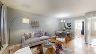 Located at 1 Chester Circle in New Brunswick, NJ, this two-story residence offers 2 bedrooms, 1 bathroom, and a versatile den spread across two thoughtfully laid-out floors. The main level features an open-concept living and dining room adorned with warm hardwood floors, soft neutral-toned walls, and natural light streaming through multiple windows. The living area provides a welcoming atmosphere, while the adjacent dining space is accented by a stylish chandelier overhead. The galley-style kitchen features light wood cabinetry, granite-style countertops, tile flooring, and black appliances, including a gas range, with a window above the sink area adding natural brightness. The den serves as a flexible space ideal for a home office, bathed in natural light. Upstairs, two well-proportioned bedrooms continue the hardwood flooring theme. The primary bedroom includes ample closet space and a window with curtains, while the second bedroom features a ceiling fan and mirrored dresser. Four closets throughout the home provide generous storage. The full bathroom is finished with tile flooring, a tub/shower combination, and a wood-tone vanity. Two staircases and a hallway connect the floors seamlessly, rounding out this efficiently designed multi-level home.