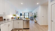 Located in Atlanta's vibrant Grant Park neighborhood, this one-bedroom, one-bathroom residence offers a thoughtfully designed single-floor layout with modern finishes throughout. Light wood-tone flooring flows through the open-concept living and kitchen areas, creating a warm, cohesive aesthetic.

The living room is bright and inviting, featuring a sliding glass door that opens to a private balcony with outdoor views of lush greenery, allowing natural light to fill the space. The kitchen is well-appointed with white shaker cabinetry, granite countertops, a classic subway tile backsplash, and a full suite of stainless steel appliances, including a side-by-side refrigerator, electric range with over-the-range microwave, and ample storage.

The bedroom is a comfortable retreat with plush carpet, a ceiling fan, natural light from a window with blinds and curtains, and access to a closet. The bathroom features wood-look flooring and clean, neutral finishes, with an open sightline into the bedroom for an airy feel.

A dedicated laundry room houses a full-size washer and dryer with built-in shelving for added storage convenience. The space combines functional design with a modern, livable atmosphere ideal for everyday comfort.