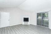 Located at 3500 Peachtree Corners Circle in Peachtree Corners, GA, this single-floor residence offers a thoughtfully laid-out interior with a blend of updated finishes and functional design. The living area is a standout space, featuring vaulted ceilings that lend an open, airy feel, a ceiling fan, and a corner fireplace with a clean white surround set against smooth luxury vinyl plank flooring. An adjacent area with matching flooring provides flexible living or dining space. The galley-style kitchen is well-appointed with white shaker cabinetry, granite-look countertops, a classic subway tile backsplash, and stainless steel appliances including a refrigerator, range with over-the-range microwave, and dishwasher. Light vinyl plank flooring and flush ceiling lighting keep the kitchen bright and practical. The bedrooms feature plush wall-to-wall carpeting, neutral-toned walls, and textured ceilings, offering comfortable and quiet retreats. The bathroom is cleanly finished with light vinyl flooring, a white vanity with modern hardware, and a full tub-shower combination. Throughout, the space maintains a cohesive, neutral palette with white trim and baseboards, creating a move-in-ready environment suitable for a variety of lifestyles.