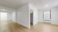 Located at 112 Hoyt St in Stamford, CT, this one-bedroom, one-bathroom residence offers a well-organized single-floor layout with a clean, bright aesthetic throughout. Light-toned hardwood floors run continuously across the living spaces, complementing the crisp white walls and creating a cohesive, airy feel.

The combined living and dining area is generously proportioned, featuring multiple windows that bring in natural light and views of greenery outside. Radiator heating and window-unit air conditioning provide year-round climate control. The space flows openly through a wide hallway connecting the main rooms.

The galley-style kitchen is efficiently designed with white cabinetry, light countertops, a stainless steel sink, dishwasher, and gas range, along with a window that adds ventilation and natural light.

The spacious primary bedroom comfortably accommodates furnishings and includes a window with outdoor views, radiator heating, and direct access to additional spaces. Five closets distributed throughout the unit offer exceptional storage capacity, a notable advantage for everyday living.

The bathroom makes a bold design statement with floor-to-ceiling black square tile, a soaking tub, and a window for natural light. The overall layout is functional and well-connected, with a hallway tying together all rooms in a logical flow.