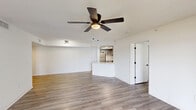 Located at 2141 Vinings Cir in Wellington, FL, this single-story, 2-bedroom, 2-bathroom home offers a well-organized layout with modern updates throughout. Light-toned luxury vinyl plank flooring runs through the main living areas and bedrooms, complementing the crisp white walls and textured ceilings fitted with ceiling fans in key rooms.

The open kitchen is a standout feature, showcasing gray shaker-style cabinetry with matte black hardware, white quartz countertops, stainless steel appliances including an electric range and built-in microwave, a deep undermount sink with a black faucet, and a skylight-style ceiling detail that adds brightness. The adjacent living room is spacious and airy, with a sliding glass door and a ceiling fan overhead.

The primary bedroom offers a comfortable footprint with a ceiling fan and natural light, while the second bedroom features a window with views of lush greenery outside. Both bathrooms are well-appointed — one includes a walk-in shower with marble-accented flooring and a window for natural light, while the other features a wide vanity with gray cabinetry, dual mirrors, and modern lighting fixtures. An attached garage provides ample storage and parking. The home's clean, neutral palette creates a move-in-ready environment throughout.