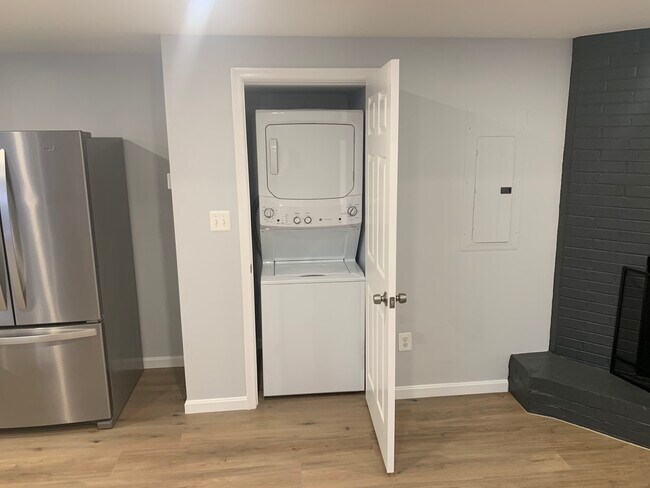 Vista de la lavadora y secadora apiladas junto a la cocina y ubicadas en la sala de estar. - 4631 Massachusetts Ave NW