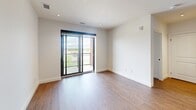 Located at 611 Davenport Road in Waterloo, Ontario, this well-appointed 2-bedroom, 2-bathroom unit offers a thoughtfully designed open-concept layout finished with warm hardwood flooring throughout. The combined kitchen and living area forms the heart of the space, anchored by a sleek central island featuring a light quartz countertop, an undermount sink, and a built-in dishwasher. The kitchen is equipped with stainless steel appliances, including a refrigerator, stove, and microwave, complemented by a mix of white lower cabinetry and rich wood-toned upper cabinets with a classic subway tile backsplash. Recessed lighting illuminates the space with a clean, modern aesthetic. The living area extends naturally from the kitchen, bathed in natural light. The primary bedroom offers generous proportions and direct access to a private balcony through sliding glass doors, framing pleasant outdoor views. The second bedroom features a large window with a roller blind, providing ample natural light. Both bathrooms are finished in neutral tones — one features a soaker tub with full-height tile surround, while the other includes a glass-enclosed walk-in shower with contemporary fixtures and a well-lit vanity.
