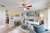 Located at 333 Lake in the Woods Drive in Melbourne, FL, this well-appointed 2-bedroom, 2-bathroom residence offers a comfortable and efficiently designed single-floor layout. The open-concept living, dining, and kitchen area serves as the heart of the home, featuring warm wood-look flooring, textured ceilings, and ceiling fans throughout. The living room is bright and inviting, with a sliding glass door that leads to a private balcony and fills the space with natural light. A pass-through window connects the kitchen to the living and dining areas, enhancing the open feel. The kitchen is equipped with warm wood cabinetry, black appliances including a range and refrigerator, and ample counter space. The dining area flows seamlessly from the living room, creating an ideal space for entertaining. The primary bedroom is a comfortable retreat, featuring large windows with plantation-style blinds that invite natural light and views of the surrounding greenery. The second bedroom is equally well-lit with similar window treatments and a ceiling fan. Both bathrooms feature wood-toned vanity cabinetry and wood-look flooring. The residence also includes three closets, a utility room, and a hallway, providing generous storage throughout.