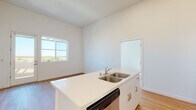 This single-story home in Stockton, CA (95209) offers a clean, modern design throughout its thoughtfully laid-out floor plan. The open-concept living and kitchen area is anchored by a large central island with a double-basin sink and dishwasher, complemented by crisp white cabinetry extending to impressive heights. Stainless steel appliances — including a refrigerator with ice maker, electric range, and over-the-range microwave — complete the well-equipped kitchen. The living area features light wood-tone flooring and soaring ceilings that enhance the sense of openness, with ample natural light streaming in through multiple windows.

The bedrooms are generously sized, with plush carpet flooring and large windows that frame open views of the surrounding landscape. At least one bedroom includes a sliding-door closet for added storage. The bathrooms are finished in a clean, minimalist style: one full bathroom features white subway tile surrounding a full-size soaking tub and shower combination, while a second bathroom offers a single-sink vanity with white cabinetry and a large mirror. Light wood-tone flooring runs consistently through the bathrooms, tying the home's palette together. The overall ambiance is bright, neutral, and move-in ready.