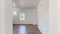 Located at 535 S Gramercy Place in the heart of Los Angeles, this efficiently designed single-floor unit offers a thoughtful layout that maximizes every square foot. The space includes a living room, kitchen, bathroom, two closets, and a dedicated entrance, all unified by warm hardwood-style flooring throughout.

The living room is bright and inviting, featuring crisp white walls, elegant crown molding, and multi-pane windows that allow generous natural light to fill the room. A classic wall sconce adds a charming touch, while a traditional cast-iron radiator contributes a sense of vintage character alongside modern updates.

The kitchen is clean and functional, outfitted with white shaker-style cabinetry, light countertops, a stainless steel sink, and a full suite of stainless steel appliances including a refrigerator, gas range, and microwave. A window above the counter provides additional natural light to the workspace.

A wide, light-filled hallway connects the rooms seamlessly, framed by large grid-pane windows and accented with wall molding details that echo the unit's classic architectural sensibility. The two closets offer practical built-in storage solutions, including a fitted closet with drawers and shelving. Crown molding, arched doorways, and panel doors throughout lend the space a cohesive, timeless aesthetic well-suited to city living.