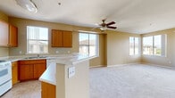 Located at 1441 Santa Lucia Rd in the Otay Ranch community of Chula Vista, California, this single-level residence offers a well-designed, open-concept floor plan finished in warm neutral tones throughout. The kitchen features warm wood cabinetry, light granite-style countertops, a peninsula breakfast bar, and tile flooring, seamlessly connecting to the living area. A built-in desk nook and a dedicated pantry closet add practical storage and workspace options to the kitchen area. The spacious living and dining area is bathed in natural light from multiple large windows and is accented by a ceiling fan overhead, with plush carpeting underfoot. A private balcony, accessible via sliding glass doors, extends the living space outdoors and offers scenic views of surrounding greenery and the rolling hills of Chula Vista. The generously sized primary bedroom includes direct balcony access, large windows framing the mountain backdrop, and leads to a walk-in closet with wrap-around shelving. The primary bathroom is equipped with a dual-sink vanity, ample cabinet storage, a large mirror, and a shower/tub combination. Additional bedrooms are carpeted and well-proportioned. A dedicated in-unit laundry closet accommodates full-size washer and dryer units, completing this functional and comfortable residence.