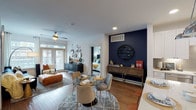 This single-story residence located at Park West Green Drive in Katy, Texas presents a thoughtfully designed open-concept layout that seamlessly connects the kitchen, dining, and living areas. The main living space is anchored by warm hardwood-style flooring and features a striking navy blue accent wall that adds a bold focal point to the dining area. Large windows throughout allow generous natural light to fill the space, enhancing the airy, welcoming atmosphere. A ceiling fan overhead completes the comfortable living zone.

The kitchen is well-equipped with white shaker cabinetry extending to the ceiling for ample storage, a clean white countertop island, stainless steel appliances including a French door refrigerator, electric range with over-the-range microwave, and dishwasher, all complemented by a subtle tile backsplash.

The bedrooms offer a calm retreat, each featuring large windows with exterior views, plush carpeting, and distinct design accents. One bedroom showcases a vaulted teal accent wall, while another provides ample natural light through double windows.

The bathrooms maintain the clean aesthetic of the home, featuring white cabinetry, stone-look countertops, large framed mirrors, and tile flooring. The primary bathroom includes a walk-in closet with built-in shelving, adding practical storage to the suite.