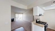 This single-floor residence offers a well-organized layout with clearly defined living, cooking, and sleeping areas. The living room serves as the central gathering space, highlighted by a classic fireplace with a white surround and a sliding glass door that floods the room with natural light and provides direct access to an outdoor area. Plush carpeting covers the living room and bedroom floors, lending warmth and comfort underfoot, while rich wood-look vinyl flooring runs throughout the kitchen, entryway, and bathrooms.

The galley-style kitchen is practical and well-appointed, featuring white cabinetry, granite-look countertops, a gas range, a dishwasher, and a double-basin sink positioned beneath a window. The open pass-through design connects the kitchen to the living area, creating a cohesive flow between spaces.

The bedrooms are generously sized with neutral-toned carpet, textured ceilings, and windows that bring in soft natural light. The primary bathroom includes a long vanity with ample cabinet storage, a granite-look countertop, a large mirror, and a walk-in glass shower stall. A secondary bathroom features hardwood-look flooring, a toilet, and a closet with a hanging rod, offering additional flexibility. Throughout, the neutral color palette and clean finishes create a bright, functional living environment.
