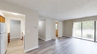 Located at 6870 E Livingstone Ave in Reynoldsburg, Ohio, this single-floor, 3-bedroom, 2-bathroom home offers a clean and functional layout with consistent light-toned luxury vinyl plank flooring throughout. The open living area provides a welcoming common space, with access to a patio through vertical-blind sliding doors that allow natural light to fill the room. A central hallway connects the bedrooms and bathrooms, with warm-toned cabinetry visible from the corridor offering a preview of the kitchen beyond. The galley-style kitchen is efficiently designed, featuring rich honey-toned wood cabinetry, white countertops, and white appliances including a refrigerator and coil-top range, with ample upper and lower cabinet storage. The three bedrooms are well-proportioned, each finished with the same light vinyl flooring, neutral walls, and windows fitted with blinds that overlook greenery outside. Bedrooms include bifold closet doors providing organized storage. The primary bedroom is notably spacious. The two bathrooms are clean and simply appointed; one features a full tub-shower combo with white subway tile surround, a vanity, and a mirror. Textured ceilings are present throughout, adding subtle character to the overall neutral, move-in-ready aesthetic of the home.