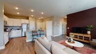 This single-story, 2-bedroom, 2-bathroom residence at 575 Concord Rd in Jefferson, GA offers a thoughtfully designed open-concept layout that seamlessly connects the kitchen, dining, and living areas. The kitchen is equipped with stainless steel appliances — including a refrigerator, range, microwave, and dishwasher — complemented by white shaker-style cabinetry, granite countertops, and a center island with bar seating. Wood-look flooring flows throughout the main living areas, adding warmth and cohesion to the space. The living room features large windows that invite abundant natural light and offer pleasant outdoor views, while a bold accent wall adds a distinct design element. Both bedrooms are generously sized, each with large windows and ample natural light. The primary bedroom features a dramatic deep-toned accent wall, while the second bedroom maintains a softer, neutral palette. Each of the two full bathrooms is outfitted with granite-topped vanities, white cabinetry, and a tub/shower combination. A versatile flex room with hardwood-style flooring and dual windows serves well as a home office or additional lounge space. Recessed lighting throughout and a neutral color scheme create a bright, modern ambiance across the entire residence.