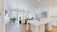 Located in Oakmont, PA, this thoughtfully designed single-floor residence offers three bedrooms and two bathrooms within a well-appointed open-concept layout. The kitchen serves as a centerpiece, showcasing a large quartz waterfall island, crisp white shaker cabinetry, a subway tile backsplash, and a full suite of stainless steel appliances, including a gas range, built-in microwave, dishwasher, and french-door refrigerator. Light hardwood flooring flows seamlessly from the kitchen into the combined living and dining area, which is bathed in natural light from a wall of large windows. The living room features crown molding, recessed lighting, and a clean, neutral palette that creates a calm, inviting ambiance. A private covered balcony extends the living space outdoors, offering sweeping views of the river and surrounding landscape. The spacious primary bedroom includes plush carpeting, direct access to the outdoors, and ample natural light. Secondary bedrooms are well-sized with sliding closet doors. Bathrooms are finished in a clean, contemporary style, one featuring a full soaking tub and shower combination. Hallways connect the rooms efficiently, completing a residence that balances modern design with comfortable, functional living.