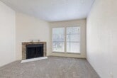 Located at 5616 Spring Valley Rd in Dallas, TX, this one-bedroom, one-bathroom residence offers a thoughtfully arranged single-floor layout. The living room serves as the heart of the home, showcasing a striking stone-surround fireplace and two large windows fitted with blinds that invite natural light while maintaining privacy. Soft wall-to-wall carpeting and a textured ceiling complete the cozy atmosphere. The kitchen is a standout feature, boasting dark cabinetry, a mosaic tile backsplash, stainless steel appliances, and an extended quartz countertop peninsula that flows seamlessly into the dining area — ideal for casual dining or entertaining. Wood-look flooring anchors the kitchen and dining spaces. The bedroom is a comfortable retreat, highlighted by a distinctive shiplap accent wall, plush carpeting, a window with natural light, and access to two closets, including a walk-in with built-in shelving and hanging rods. The bathroom features a quartz-top vanity with dark cabinetry, a framed mirror, and a tub-shower combination. A hallway connects all areas efficiently, rounding out a well-organized and stylish living space.