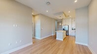 Located at 4901 Helios Cir in Kissimmee, FL, this well-designed one-bedroom, one-bathroom unit offers a thoughtfully laid-out single-floor plan with a clean, modern aesthetic throughout. Light-toned hardwood flooring flows seamlessly across all rooms, complemented by neutral warm-gray walls and crisp white trim that create a bright, cohesive ambiance.

The open-concept kitchen and living area serves as the heart of the unit. The kitchen stands out with tall white shaker cabinets, a bold navy herringbone tile backsplash, a large center island with white quartz countertops, and a full suite of stainless steel appliances including a side-by-side refrigerator, range, microwave, and dishwasher. Pendant lighting above the island adds a refined touch, and a built-in open shelving unit provides additional display and storage space.

The living room benefits from large windows and a glass door that fill the space with natural light and offer outdoor views. The bedroom is a comfortable, well-proportioned room featuring oversized windows that bring in ample daylight. The bathroom includes a soaking tub with a tile-surround shower and access to a walk-in closet with wire shelving. A dedicated laundry area houses a stacked washer and dryer for added convenience.