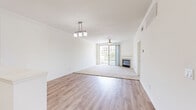 Located in San Diego's Mission Valley area, this 3-bedroom, 2-bathroom residence offers a thoughtfully designed single-floor layout. The open-concept living and dining area is a standout feature, combining light hardwood-style flooring with plush carpet in the living zone, a ceiling fan, a cozy fireplace, and large sliding glass doors that invite abundant natural light and outdoor views. A pendant light fixture adds a refined touch overhead.

The kitchen is well-appointed with crisp white cabinetry, striking marble-look quartz countertops, stainless steel appliances including a dishwasher, range, microwave, and refrigerator, and a deep single-basin sink. An in-unit washer is conveniently accessible from the kitchen area. The open pass-through design connects the kitchen seamlessly to the living space.

The bedrooms are carpeted for comfort, with the primary bedroom offering generous proportions and access to a closet. Additional bedrooms feature ceiling fans, natural light from windows, and dedicated closet space. Both bathrooms are finished with quartz-topped white vanities, hardwood-style flooring, and full tub-shower combinations. The overall aesthetic is clean, bright, and modern throughout.