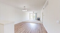 Located in San Diego's Mission Valley area, this 3-bedroom, 2-bathroom residence offers a thoughtfully designed single-floor layout. The open-concept living and dining area is a standout feature, combining light hardwood-style flooring with plush carpet in the living zone, a ceiling fan, a cozy fireplace, and large sliding glass doors that invite abundant natural light and outdoor views. A pendant light fixture adds a refined touch overhead.

The kitchen is well-appointed with crisp white cabinetry, striking marble-look quartz countertops, stainless steel appliances including a dishwasher, range, microwave, and refrigerator, and a deep single-basin sink. An in-unit washer is conveniently accessible from the kitchen area. The open pass-through design connects the kitchen seamlessly to the living space.

The bedrooms are carpeted for comfort, with the primary bedroom offering generous proportions and access to a closet. Additional bedrooms feature ceiling fans, natural light from windows, and dedicated closet space. Both bathrooms are finished with quartz-topped white vanities, hardwood-style flooring, and full tub-shower combinations. The overall aesthetic is clean, bright, and modern throughout.