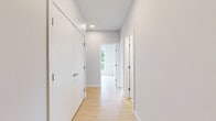 Located at 2540–2590 Lonsdale Avenue in North Vancouver, this well-appointed three-bedroom, two-bathroom residence offers a clean, contemporary design across a single level. Light hardwood flooring runs throughout the living areas and bedrooms, complementing the neutral grey-white palette that gives the space a bright, airy feel.

The open-concept living and dining area connects seamlessly to the kitchen, which features modern cabinetry and stainless steel appliances. Large floor-to-ceiling windows flood the space with natural light and frame lush, tree-lined views — a standout feature of the primary bedroom, which benefits from its generous proportions and direct outdoor vistas through expansive glazing with balcony access.

The two additional bedrooms are well-sized and versatile, each finished with the same warm hardwood flooring and clean white walls. A dedicated closet provides convenient storage. Both bathrooms are finished to a high standard, featuring marble-effect floor and wall tiling, soaker tubs with overhead showers, and sleek floating vanities with undermount sinks and chrome fixtures.

Two hallways connect the rooms efficiently, contributing to a practical and flowing layout. The overall ambiance is modern and understated, with quality finishes throughout that reflect a thoughtfully designed residential space in one of North Vancouver's well-connected neighbourhoods.