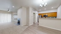 Located at 3501 E Camelback Rd in Phoenix, AZ, this well-appointed 2-bedroom, 2-bathroom single-floor residence offers a thoughtfully designed layout with a neutral color palette and clean finishes throughout. The open living area features plush carpeting and a fireplace, creating a welcoming focal point, while light wood-look flooring extends through the kitchen, hallway, and wet areas. The kitchen is equipped with warm honey-toned cabinetry, white quartz countertops, a tiled backsplash, stainless steel appliances including a refrigerator, microwave, and dishwasher, and a breakfast bar for casual dining. A modern chandelier adds a refined touch overhead. Both bathrooms feature wood-toned vanities with white countertops and tub-shower combinations with tile surrounds. The primary bedroom is generously sized, carpeted, and includes a spacious walk-in closet outfitted with built-in shelving and dual hanging rods. The second bedroom offers sliding glass door access with ample natural light from large windows. A dedicated laundry room with side-by-side washer and dryer and overhead shelving adds practical convenience. Two closets and a hallway complete the efficient floor plan of this Phoenix residence.