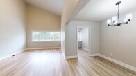 Located at 23 Lake Shore Dr in Watervliet, NY, this well-appointed single-floor, 3-bedroom, 2-bathroom home offers a thoughtfully designed layout across a generous footprint. The living area features light-toned hardwood-style flooring, warm neutral walls, and soaring vaulted ceilings that lend an open, airy feel. Large windows allow abundant natural light to fill the space, offering views of the surrounding greenery.

The kitchen stands out as a highlight, showcasing crisp white shaker-style cabinetry with black hardware, quartz countertops, a white subway tile backsplash, and stainless steel appliances including a gas range and dishwasher. The glass-front upper cabinets add a refined touch to this modern cooking space.

The spacious primary bedroom features impressively tall ceilings, a large window, dual sliding-door closets, and an adjacent open shelving nook for added storage. The additional bedrooms offer plush carpeting and generous closet space, providing comfortable and functional retreats. Both bathrooms are appointed with clean white tiled tub-shower combinations, gray cabinetry, and matte black fixtures. One bathroom includes built-in shelving alongside the tub for additional storage. A utility room, hallway, and six closets throughout the home round out a practical and well-organized floor plan.