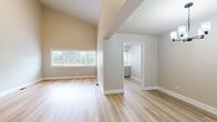 Located at 23 Lake Shore Dr in Watervliet, NY, this well-appointed single-floor, 3-bedroom, 2-bathroom home offers a thoughtfully designed layout across a generous footprint. The living area features light-toned hardwood-style flooring, warm neutral walls, and soaring vaulted ceilings that lend an open, airy feel. Large windows allow abundant natural light to fill the space, offering views of the surrounding greenery.

The kitchen stands out as a highlight, showcasing crisp white shaker-style cabinetry with black hardware, quartz countertops, a white subway tile backsplash, and stainless steel appliances including a gas range and dishwasher. The glass-front upper cabinets add a refined touch to this modern cooking space.

The spacious primary bedroom features impressively tall ceilings, a large window, dual sliding-door closets, and an adjacent open shelving nook for added storage. The additional bedrooms offer plush carpeting and generous closet space, providing comfortable and functional retreats. Both bathrooms are appointed with clean white tiled tub-shower combinations, gray cabinetry, and matte black fixtures. One bathroom includes built-in shelving alongside the tub for additional storage. A utility room, hallway, and six closets throughout the home round out a practical and well-organized floor plan.