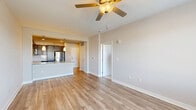 Located at 5220 Center St in Williamsburg, VA, this well-appointed one-bedroom, one-bathroom residence offers a thoughtfully designed single-floor layout. The open-concept living and kitchen area serves as the heart of the home, featuring light-toned hardwood-style flooring, neutral walls, and a ceiling fan that enhances airflow throughout. The kitchen is outfitted with rich dark cabinetry, granite countertops, a peninsula island with an undermount sink, pendant lighting, and a full suite of stainless steel appliances including a refrigerator, range, microwave, and dishwasher. A subway tile backsplash adds a clean, modern touch. The spacious bedroom offers plush carpeting, a ceiling fan, a large window with neighborhood views, and two closets for ample storage. The bathroom continues the upscale aesthetic with granite countertops, dark cabinetry, an undermount vanity sink, and a full tub-shower combination with tiled surround. Hardwood-style flooring extends throughout the main living areas. A dedicated laundry area adds everyday convenience. The overall ambiance is clean, modern, and move-in ready, ideal for comfortable single-floor living.