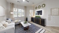 Located at 4949 N 7th St in Phoenix, Arizona, this thoughtfully designed 2-bedroom, 2-bathroom residence offers a comfortable and modern single-level layout. The open-concept kitchen is a standout feature, showcasing dark charcoal cabinetry, sleek white quartz countertops, stainless steel appliances including a refrigerator and microwave, and a large central island with a built-in sink and seating — all illuminated by stylish pendant lighting. The kitchen flows seamlessly into the living room, which is bright and airy with large windows that invite natural light and views of the surrounding greenery. Wood-look flooring runs throughout the main living areas, adding warmth and continuity. Both bedrooms are carpeted and well-sized, each with generous closet space featuring multi-rod hanging systems. The primary bedroom offers a walk-in closet and its own en-suite bathroom. The second bathroom features a dark-toned vanity with a white countertop and wood-look tile flooring. A dedicated laundry room includes a full-size washer and dryer along with built-in shelving for added storage. A connecting hallway ties the layout together efficiently, creating a cohesive and functional living environment throughout.