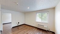 Located at 123 E McCullough Dr, Unit 314, in Charlotte, NC, this one-bedroom, one-bathroom unit offers a practical and functional layout across a single floor. The space is finished with warm wood-style flooring throughout, providing a cohesive look that connects each room seamlessly.

The living area is open and well-proportioned, featuring neutral white walls, dark baseboards, and a textured popcorn ceiling with recessed lighting. A window with horizontal blinds allows natural light to filter in, offering views of surrounding greenery. A wall-mounted HVAC unit provides independent climate control.

The bedroom is a comfortable, generously sized room that mirrors the living area's design with the same wood-style flooring, textured ceiling, and a window overlooking lush outdoor foliage. Recessed lighting and a wall-mounted HVAC unit are also present, ensuring year-round comfort.

A dedicated closet provides convenient storage adjacent to the main living spaces. The bathroom is clean and straightforward, featuring wood-style flooring consistent with the rest of the unit, a toilet, a vanity with sink, and a chrome double towel bar mounted on the wall.

Overall, this unit presents a clean, no-frills interior well-suited for those seeking a practical living space in Charlotte's University City area.