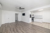 Located at 1216 W 37th Pl in Los Angeles, CA, this well-maintained 2-bedroom, 1-bathroom unit offers a thoughtfully designed single-level layout. The interior is defined by a consistent palette of crisp white walls and light wood-tone vinyl plank flooring that flows throughout the entire space, creating a clean and cohesive aesthetic.

The living room is an open, airy space equipped with a wall-mounted mini-split A/C unit and direct sightlines into the kitchen, making it ideal for everyday living. The kitchen features white shaker-style cabinetry with ample upper and lower storage, light quartz countertops, a stainless steel sink, and a gas range, offering a functional and modern cooking environment.

Both bedrooms are comfortably sized with white walls and natural light provided by windows with blinds. The primary bedroom includes a wall-mounted A/C unit and a dedicated closet, while the second bedroom also features its own closet for convenient storage. A connecting hallway links the rooms efficiently.

The bathroom is neatly finished with large-format marble-look tile surrounding a tub-shower combo with a sliding glass enclosure, brushed nickel fixtures, a white vanity, and a mirrored medicine cabinet. The unit also includes a dedicated hallway connecting all rooms for a practical and organized flow throughout.