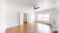 Located at 511 S Serrano Ave in the heart of Los Angeles, this single-floor unit offers a well-organized and functional layout across a cozy footprint. The living room serves as the centerpiece of the space, showcasing warm hardwood flooring, crisp white walls, and a ceiling fan that adds both style and practicality. Multiple windows allow natural light to pour in, creating a bright and airy atmosphere. Elegant double doors connect the living area to the rest of the unit, enhancing the open flow. The galley-style kitchen is a standout feature, dressed in all-white cabinetry and countertops with a classic black-and-white checkered tile floor that adds a timeless character. It is equipped with a sink, stove, refrigerator, and microwave, making efficient use of the available space. The bathroom maintains a clean, all-white aesthetic with marble-look tile flooring, a pedestal sink, a full soaking tub with shower, white subway tile surround, and a louvered window for natural ventilation. Two closets provide ample storage, while two hallways help connect the rooms with ease. The textured ceilings throughout add a subtle architectural detail, tying the space together with a cohesive, classic Los Angeles residential character.