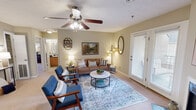 Located at 505 Fox Crossing Blvd in Knoxville, Tennessee, this two-bedroom, two-bathroom residence offers a thoughtfully designed single-floor layout with a warm, neutral color palette throughout. The living room serves as the heart of the home, featuring a wood-burning fireplace, a ceiling fan with light fixture, and French doors that open to an outdoor area, allowing natural light to fill the space. Carpet flooring adds comfort underfoot, complementing the inviting atmosphere. Adjacent to the living room, the dedicated dining area is defined by an elegant chandelier overhead, offering a distinct space for meals. The galley-style kitchen is equipped with dark granite-style countertops, light wood cabinetry, a double stainless steel sink, and black appliances, with tile flooring for easy maintenance. The spacious primary bedroom features carpet, a walk-in closet, and a private en-suite bathroom with a granite-topped vanity and warm wood cabinetry. The second bedroom is generously sized and well-lit by a window. The second bathroom mirrors the same granite countertop and wood vanity design. Two closets and a hallway complete the functional floor plan, making this a well-organized and comfortable Knoxville residence.
