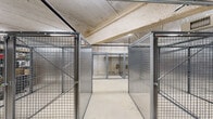 Located at 2305 Sokol Ct in Darien, Illinois, this single-floor storage facility offers a generously sized, open layout designed to accommodate a variety of storage needs. The space is organized around a series of individual storage units constructed from heavy-duty wire mesh and solid metal panel enclosures, each secured with lockable doors, providing both visibility and security for stored contents.

The flooring throughout consists of smooth, light-colored concrete, contributing to a clean and functional environment. Overhead, the exposed concrete ceiling hosts a well-developed network of utility systems, including HVAC ductwork, plumbing pipes, sprinkler lines, and electrical conduits — all indicative of a professionally built and code-compliant facility. Fluorescent linear lighting is mounted along the ceiling, ensuring consistent illumination throughout the space.

The structural walls are composed of concrete masonry units and poured concrete, reinforcing the facility's durable, industrial character. The layout allows for clear circulation pathways between the storage units, enabling efficient access. The combination of wire mesh cages and solid metal enclosures accommodates different storage requirements, from open shelving to fully enclosed units. Overall, this facility presents a well-organized, secure, and practical storage environment suited for commercial or multi-tenant use.