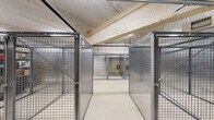 Located at 2305 Sokol Ct in Darien, Illinois, this single-floor storage facility offers a generously sized, open layout designed to accommodate a variety of storage needs. The space is organized around a series of individual storage units constructed from heavy-duty wire mesh and solid metal panel enclosures, each secured with lockable doors, providing both visibility and security for stored contents.

The flooring throughout consists of smooth, light-colored concrete, contributing to a clean and functional environment. Overhead, the exposed concrete ceiling hosts a well-developed network of utility systems, including HVAC ductwork, plumbing pipes, sprinkler lines, and electrical conduits — all indicative of a professionally built and code-compliant facility. Fluorescent linear lighting is mounted along the ceiling, ensuring consistent illumination throughout the space.

The structural walls are composed of concrete masonry units and poured concrete, reinforcing the facility's durable, industrial character. The layout allows for clear circulation pathways between the storage units, enabling efficient access. The combination of wire mesh cages and solid metal enclosures accommodates different storage requirements, from open shelving to fully enclosed units. Overall, this facility presents a well-organized, secure, and practical storage environment suited for commercial or multi-tenant use.