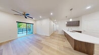 Located at 983 W State St in Hurricane, Utah, this well-appointed 3-bedroom, 2-bathroom unit offers a thoughtfully designed single-floor layout. The open-concept living area seamlessly connects the living room, dining area, and kitchen, all finished with light-toned hardwood flooring that enhances the bright, airy atmosphere. Recessed lighting and a ceiling fan keep the space comfortable, while a sliding glass door leads directly to a private balcony with outdoor views.

The kitchen is a standout feature, equipped with rich dark wood cabinetry, white quartz countertops, stainless steel appliances including an electric range, pendant lighting over the sink, and access to a dedicated pantry for additional storage.

The primary bedroom is generously sized, with direct balcony access, a ceiling fan, and a walk-in closet outfitted with dual hanging rods and shelving. The additional bedrooms feature plush carpeting, ceiling fans, and natural light from exterior windows. Each bedroom benefits from its own closet space.

Both bathrooms are finished in a clean, modern style with dark wood vanities, white countertops, and tub-shower combinations. A dedicated laundry room and a central hallway connecting all rooms round out this functional and well-designed home.