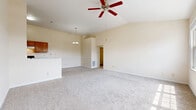 Located at 1514 Aspen Pines Dr in Wilder, KY, this single-story home offers three bedrooms, two bathrooms, and a thoughtfully arranged floor plan. The open-concept living and kitchen area is a standout feature, highlighted by soaring vaulted ceilings, a ceiling fan, and large multi-pane windows that flood the space with natural light. Plush wall-to-wall carpeting runs throughout the living area and bedrooms, lending a warm, comfortable feel. A pendant chandelier over the dining area adds a decorative touch, while a kitchen pass-through connects the living space seamlessly to the galley-style kitchen. The kitchen is well-appointed with warm wood cabinetry, ample counter space, a double sink, a dishwasher, and a full suite of appliances, including an electric range and refrigerator, complemented by easy-care hardwood-style flooring. The generously sized primary bedroom features a wide triple-pane window with outdoor views, a ceiling fan, and access to a walk-in closet with built-in shelving. The additional bedrooms also include ceiling fans, carpeting, and natural light. The bathrooms are clean and functional, featuring a tub-shower combination. A utility room and a hallway complete the efficient layout of this well-maintained home.