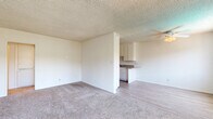 Located at 18547 Plummer St in the Northridge neighborhood of Los Angeles, CA, this 2-bedroom, 1-bathroom unit offers a practical and comfortable single-floor layout. The open living area greets you with light wood-look flooring, multiple large windows that invite abundant natural light, a wall-mounted A/C unit for year-round comfort, and a ceiling fan overhead. Textured ceilings run throughout the home, adding a classic residential character. The kitchen sits adjacent to the living space and features white cabinetry and countertops, providing functional storage and prep space. Both bedrooms are carpeted for added comfort; the spacious primary bedroom offers generous square footage with a closet, a textured ceiling, and access to a hallway leading to the bathroom. The second bedroom also features carpet flooring, a ceiling fan, and a window with neighborhood views. The full bathroom is finished with wood-look tile flooring, white cabinetry with a granite-style countertop, a soaking tub, toilet, and a bright window for natural ventilation. A connecting hallway ties the rooms together, completing this clean, move-in-ready layout.