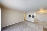 Located in Houston, TX, this single-story 2-bedroom, 2-bathroom unit offers a practical and comfortable layout. The main living area features light luxury vinyl plank flooring, a striking black-tiled fireplace as a focal point, and a sliding glass door with vertical blinds that fills the space with natural light. A second living area connects seamlessly, providing flexible use of space.

The combined dining and kitchen area features a peninsula-style breakfast bar that opens to the living room, white cabinetry, marble-patterned countertops, and black appliances including a refrigerator, electric range, and range hood. A pantry and utility room add valuable storage and functionality.

Both bedrooms are generously sized, each equipped with a ceiling fan and window with blinds to allow natural light. The spacious primary bedroom includes closet access, while the layout overall benefits from five closets distributed throughout for ample storage.

The two full bathrooms each include a tub-shower combination with white tile surround. A dedicated laundry area and hallway complete the floor plan. The neutral color palette of warm beige walls and light flooring throughout creates a cohesive, airy ambiance suited for everyday living.