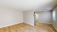 Located at 8201 Madison Ave in Indianapolis, Indiana, this 1-bedroom, 1-bathroom unit offers a clean, modern aesthetic throughout its efficiently designed single-floor layout. Light-toned luxury vinyl plank flooring runs through the main living areas, complementing the neutral greige wall palette and crisp white trim work that give the space a bright, cohesive feel.

The combined kitchen and living area serves as the heart of the unit. The kitchen is outfitted with dark charcoal cabinetry, a full suite of appliances including a stainless refrigerator, gas range, and dishwasher, and a single-basin sink beneath overhead lighting. The open living room area benefits from a sliding glass door fitted with vertical blinds, allowing generous natural light and outdoor views.

The bedroom is a comfortably sized retreat featuring plush wall-to-wall carpeting, a dedicated closet with double doors, and a window with horizontal blinds for privacy and light control. Two hallways connect the living spaces to the bedroom and bathroom, contributing to a logical and practical flow throughout the unit.

The bathroom is finished in a clean, minimalist style with light wood-look flooring, a white vanity with a single sink, a tub-shower combination, a toilet, and a window that brings in natural light. The overall ambiance of the unit is bright, tidy, and move-in ready.