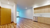 This 590 square foot apartment, located at 4750 32nd Ave S in Seattle, offers a thoughtful blend of modern design and functionality. The single-floor layout comprises one bedroom, one bathroom, and an open-concept kitchen and living area. The primary bedroom, measuring 130 square feet, provides ample space and features a large window and carpeted flooring for comfort.

The kitchen is a standout feature, boasting sleek light wood cabinetry, stainless steel appliances, and a stylish subway tile backsplash. The L-shaped design maximizes efficiency, while recessed lighting adds a contemporary touch. The living area, with its hardwood flooring and large windows, creates a bright and inviting atmosphere.

The bathroom is well-appointed with a full-sized tub, modern fixtures, and clean lines. Throughout the apartment, neutral tones and an abundance of natural light create a sense of spaciousness. The use of consistent flooring – hardwood in main living areas and carpet in the bedroom – adds to the cohesive design. Built-in closets offer practical storage solutions. This apartment combines modern aesthetics with practical living, ideal for those seeking a contemporary urban lifestyle.