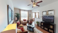 This well-appointed single-floor, 1-bedroom, 1-bathroom residence offers a thoughtfully designed layout with a seamless flow between living spaces. The living room is bright and welcoming, featuring hardwood-style flooring, large windows that invite generous natural light, and a ceiling fan overhead. It opens to a dedicated dining area set within a charming bay window nook, also equipped with a ceiling fan, offering pleasant outdoor views and an airy atmosphere. The kitchen is functional and well-equipped, showcasing warm wood cabinetry, granite-style countertops, a mosaic tile backsplash, and black appliances including a range, microwave, and dishwasher. The bedroom is a comfortable retreat with plush carpeting, a ceiling fan, and a large window with outdoor views. It connects to a generously sized walk-in closet with full rod storage and ample floor space. The bathroom features a long vanity with substantial counter space, wood-tone cabinetry, hardwood-style flooring, and a tiled shower area. A dedicated in-unit laundry room with a full-size washer and dryer, wire shelving, and hardwood-style floors adds exceptional everyday convenience to this well-rounded residence.
