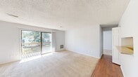 Located at 157 Tree Top Dr in Fayetteville, NC, this single-floor residence offers a well-organized layout with two bedrooms, two bathrooms, a living room, kitchen, and connecting hallways. The living room is a bright, open space featuring plush carpeting, a textured ceiling, and sliding glass doors flanked by vertical blinds that open onto a private outdoor deck — allowing natural light to flood the interior and offering pleasant views of the surrounding trees. A wall-mounted heating unit adds functional convenience to the space. The kitchen features light-toned countertops, white cabinetry, wood-look flooring, and includes a refrigerator and dishwasher. The primary bedroom is generously sized with soft carpeting, a large walk-in closet, and a window that brings in ample natural light. The second bedroom is similarly carpeted and well-lit, offering a comfortable and quiet retreat. Both bathrooms are cleanly appointed, featuring vanities with speckled countertops, framed mirrors, and tub-shower combinations with wood-look flooring. Hallways connect the spaces efficiently throughout the home, contributing to a practical and easy-to-navigate floor plan.