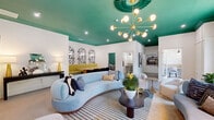 This thoughtfully designed single-floor space makes a striking first impression with its bold, eclectic interior aesthetic. The living room serves as the centerpiece, featuring a dramatic emerald green ceiling accented by a statement Sputnik-style brass chandelier and an ornate sunburst medallion. A curved powder-blue sofa anchors the seating area atop a striped area rug, complemented by rounded accent chairs and a dark wood coffee table. Large arched windows flood the space with natural light and offer views of the surrounding greenery. The walls are crisp white, creating a vivid contrast with the rich ceiling color and curated artwork throughout.

An adjacent dining nook features a mustard-yellow banquette beneath three arched, wallpapered alcoves, paired with sleek black velvet chairs on brass legs and herringbone-patterned hardwood flooring — a refined yet playful composition. The hallways connect the spaces efficiently while maintaining the design continuity of the overall interior.

The office is an intimate, focused room distinguished by a bold teal accent wall adorned with a gold and teal polka-dot pattern. A round white table surrounded by light gray upholstered chairs provides a clean meeting or work surface, while a wall-mounted display screen adds functionality. The space as a whole balances bold visual design with practical use of every square foot.