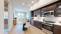 Located at 115 Healthy Way in Folsom, CA, this well-appointed 2-bedroom, 2-bathroom residence offers a thoughtfully designed single-level layout. The open-concept kitchen, dining, and living area forms the heart of the home, featuring rich dark-walnut cabinetry extending to the ceiling, light quartz countertops, a decorative tile backsplash, and a full suite of stainless steel appliances including a gas range, dishwasher, microwave, and refrigerator. Light wood-style flooring runs throughout the main living areas, complementing the soft, neutral color palette and recessed lighting overhead. The living room is bright and welcoming, with large windows that invite natural light and views of the surrounding neighborhood. Both bedrooms are carpeted and generously proportioned, with the primary bedroom offering comfortable space for a full furniture arrangement. The bathrooms are finished with dark wood vanities, white quartz counters, illuminated mirrors, and tile-surround walk-in showers. Additional highlights include three closets providing ample storage, a dedicated laundry area, hallways connecting all rooms efficiently, and a private balcony. The overall ambiance is clean, modern, and move-in ready.