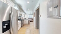 Located at 3915 N Pennsylvania Ave in Oklahoma City, OK, this efficiently designed one-bedroom, one-bathroom home makes excellent use of its single-floor layout. The open-concept living area seamlessly connects the kitchen, dining, and living spaces, creating a bright and functional environment. The kitchen is outfitted with white shaker-style cabinetry, dark countertops, stainless steel appliances including a gas range and built-in microwave, a farmhouse sink, and a peninsula with bar seating — ideal for casual dining. Recessed and pendant lighting add a polished touch throughout. Light-toned concrete floors run throughout the main living areas, lending a clean, modern aesthetic. The bedroom is generously sized, bathed in natural light from multiple windows dressed with white curtains and wood blinds. A ceiling fan, recessed lighting, and two closets with sage-toned panel doors add both comfort and practicality. The bathroom features classic white subway tile in the tub-shower surround with a built-in niche, complemented by matte black accents. Additional conveniences include a dedicated laundry area and utility room. The overall ambiance is clean, modern, and thoughtfully appointed.
