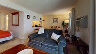Located at 183 Hartford Rd in the Fairway neighborhood of New Britain, CT, this single-floor residence offers a well-organized and functional layout designed for comfortable everyday living. The open living and dining area serves as the heart of the home, featuring light-toned carpeting, neutral walls, and a built-in breakfast bar with seating — ideal for casual meals or entertaining. A window with blinds and curtains allows natural light to brighten the space, while a dedicated dining nook provides a charming spot for sit-down meals. The kitchen is efficiently designed, featuring dark wood cabinetry, a black countertop, a white electric range, and a white tile backsplash that adds a clean, classic look. The bedroom is a comfortable retreat, highlighted by a wall of built-in closets offering generous storage space, soft carpeting, and warm, subdued lighting that contributes to a restful ambiance. The full bathroom includes a tub-shower combination, wood-style flooring, and a clean, straightforward design. Throughout the residence, the consistent use of neutral tones and practical finishes creates a cohesive and livable atmosphere suited for a range of lifestyles.