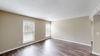 Located at 409 Tradewinds Dr in Fayetteville, NC, this single-story, 2-bedroom, 2-bathroom home offers a well-organized layout with a comfortable and practical living environment. The living room features wood-look hard flooring, neutral beige walls, and multiple windows fitted with blinds that allow for generous natural light. Built-in shelving adds a functional and decorative touch to the living area. The kitchen is equipped with white cabinetry, granite-look countertops, and includes a dishwasher and range, all set over matching wood-look flooring. Both bedrooms are carpeted in a warm neutral tone, offering a cozy atmosphere. The spacious primary bedroom includes access to a walk-in closet with dual hanging rods and built-in shelving, providing substantial storage. Both bathrooms feature full tub-and-shower combinations with white surround panels, built-in niche shelving, and brushed nickel hardware. Throughout the home, textured ceilings, clean white baseboards, and a consistent warm neutral color palette create a cohesive and tidy aesthetic. Three closets in total ensure ample storage across the home. Two hallways connect the spaces efficiently, making the floor plan easy to navigate.
