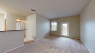 Located at 1400 E University Dr in Denton, TX, this single-story, 2-bedroom, 1-bathroom residence offers a practical and comfortable layout. The open living room is carpeted and bathed in natural light through a large window and glass-paneled entry door, creating a bright and welcoming atmosphere. Adjacent to the living area, the kitchen features wood-tone cabinetry and a breakfast bar, providing a functional space for everyday cooking and dining.

The primary bedroom is a generously sized retreat, featuring a ceiling fan, two windows that invite natural light, and access to a spacious walk-in closet fitted with wire shelving and rods for organized storage. The second bedroom also includes a ceiling fan, a window with outdoor views, and its own closet. Both bedrooms are finished with plush carpeting and neutral-toned walls throughout.

The full bathroom is clean and functional, featuring a tiled tub-shower combination with safety grab bars, wood-look flooring, and cabinet storage. A dedicated utility room adds everyday convenience. With three closets total across the unit, storage is plentiful. The consistent use of neutral tones, carpet flooring in main living areas, and wood-look flooring in key spaces gives the home a cohesive, understated aesthetic.